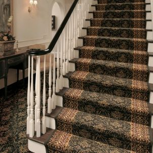 A staircase with a carpeted staircase and a white railing