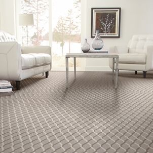 A living room with a couch , chair , table and vases on the floor.