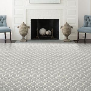 A living room with a fireplace , chairs and a rug.