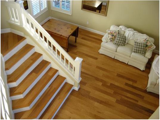 An aerial view of a living room with hardwood floors and stairs