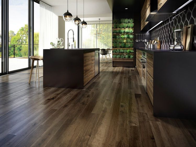 A kitchen with a wooden floor and black cabinets