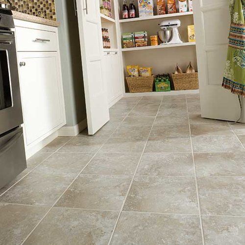 A kitchen with a tiled floor and shelves filled with food