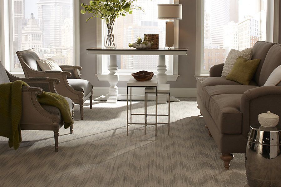 A living room with a couch , chairs and a table