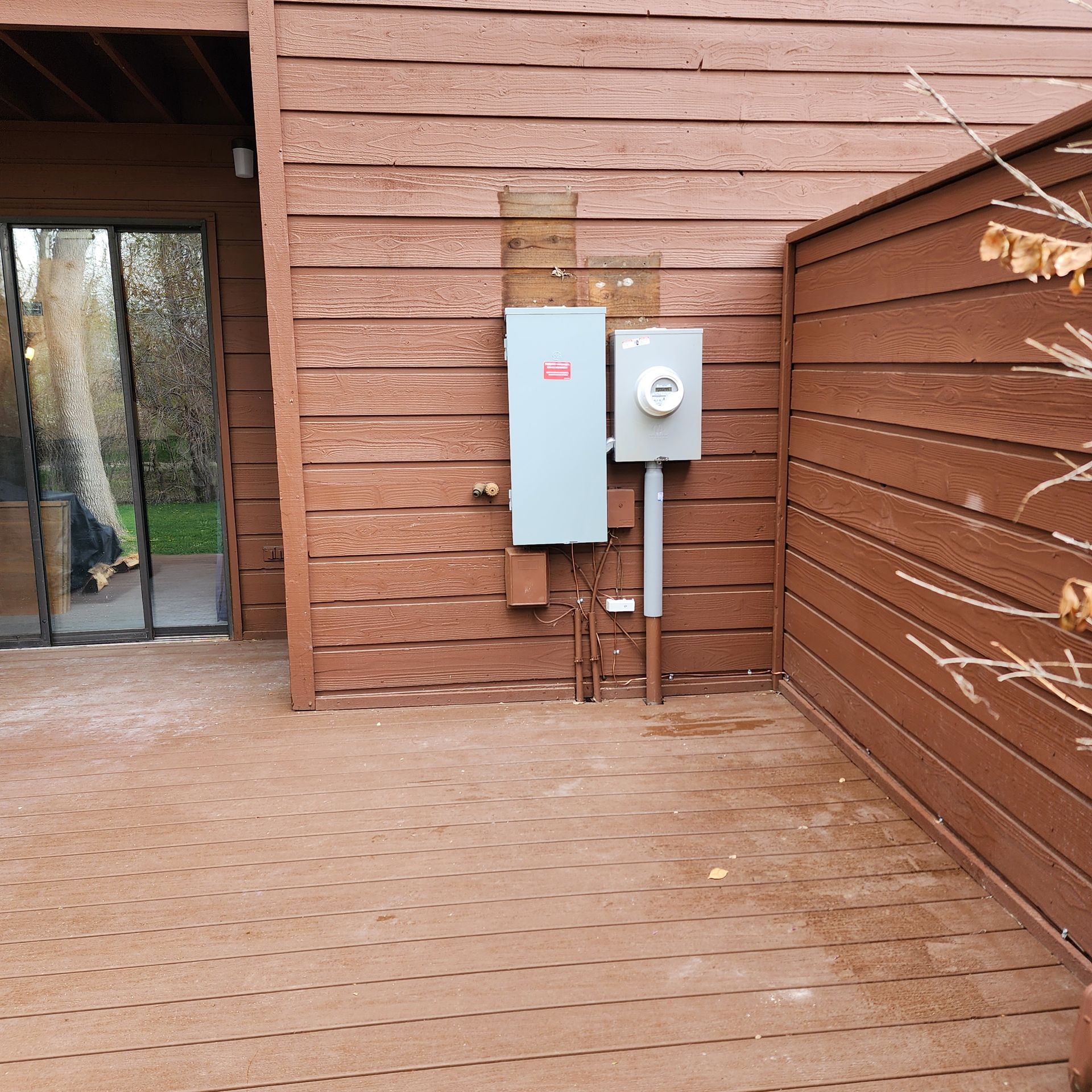 A wooden deck with a electrical box on the side of it