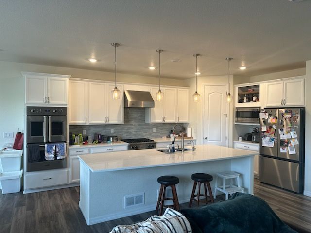 A kitchen with white cabinets and stainless steel appliances