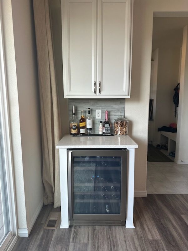 There is a wine cooler in the middle of the room.