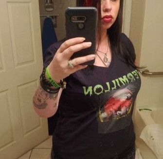 A woman is taking a selfie in a bathroom mirror.