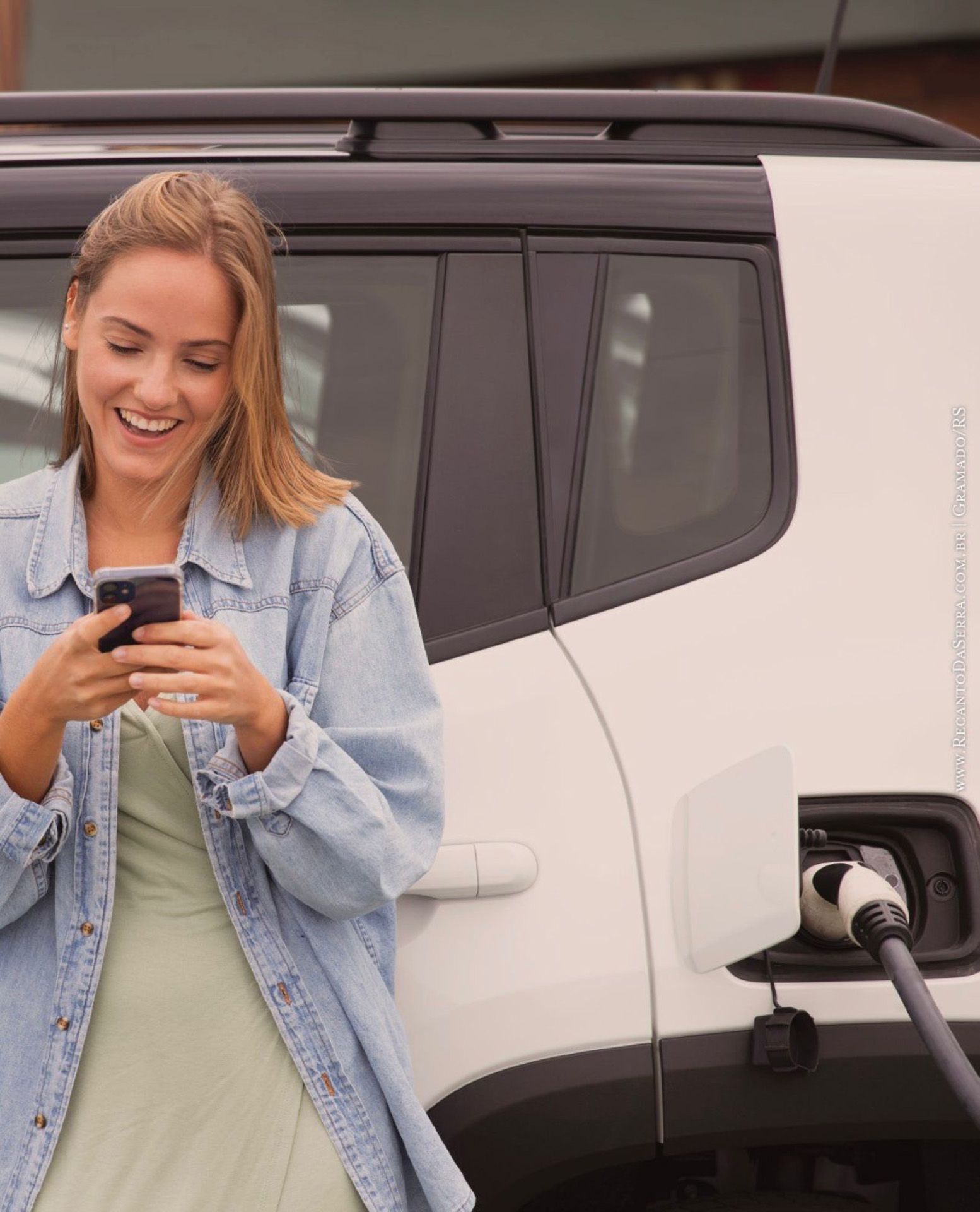 Carros estacionados em fila numa rua de paralelepípedos; foco num carro cinza em primeiro plano.