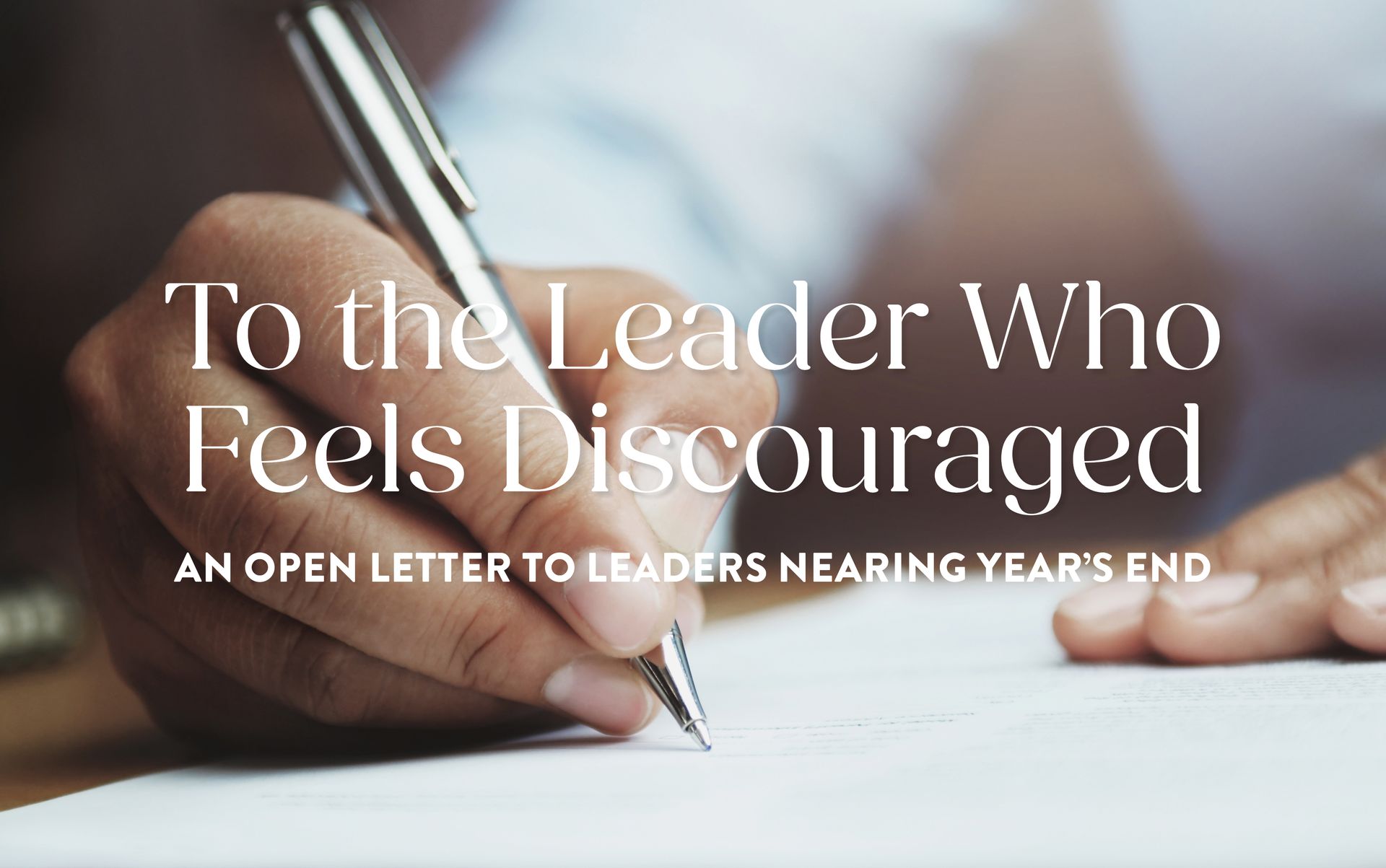 Person writing with a pen, text overlay: