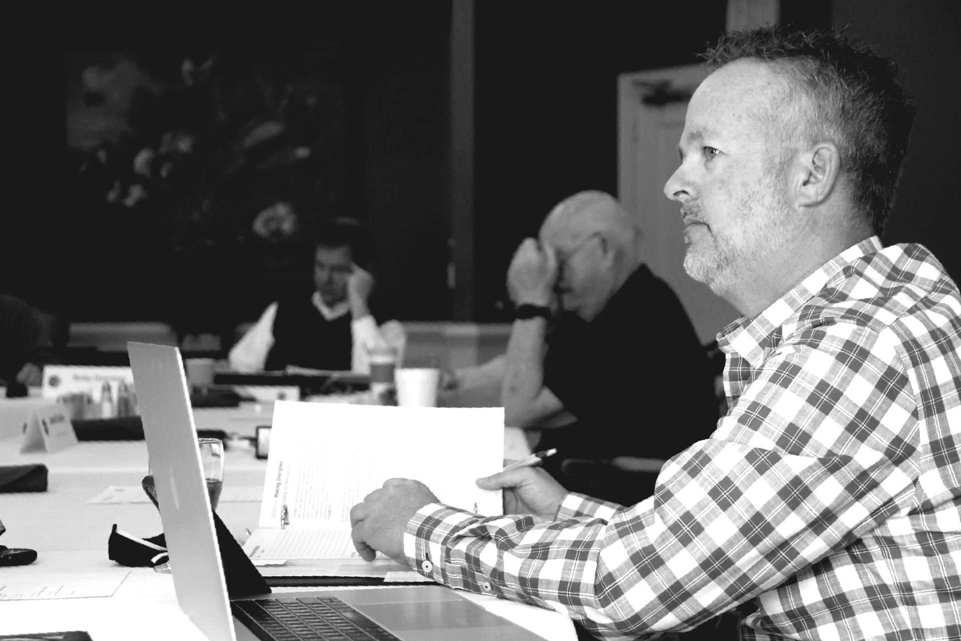 a man is sitting at a table using a laptop computer .