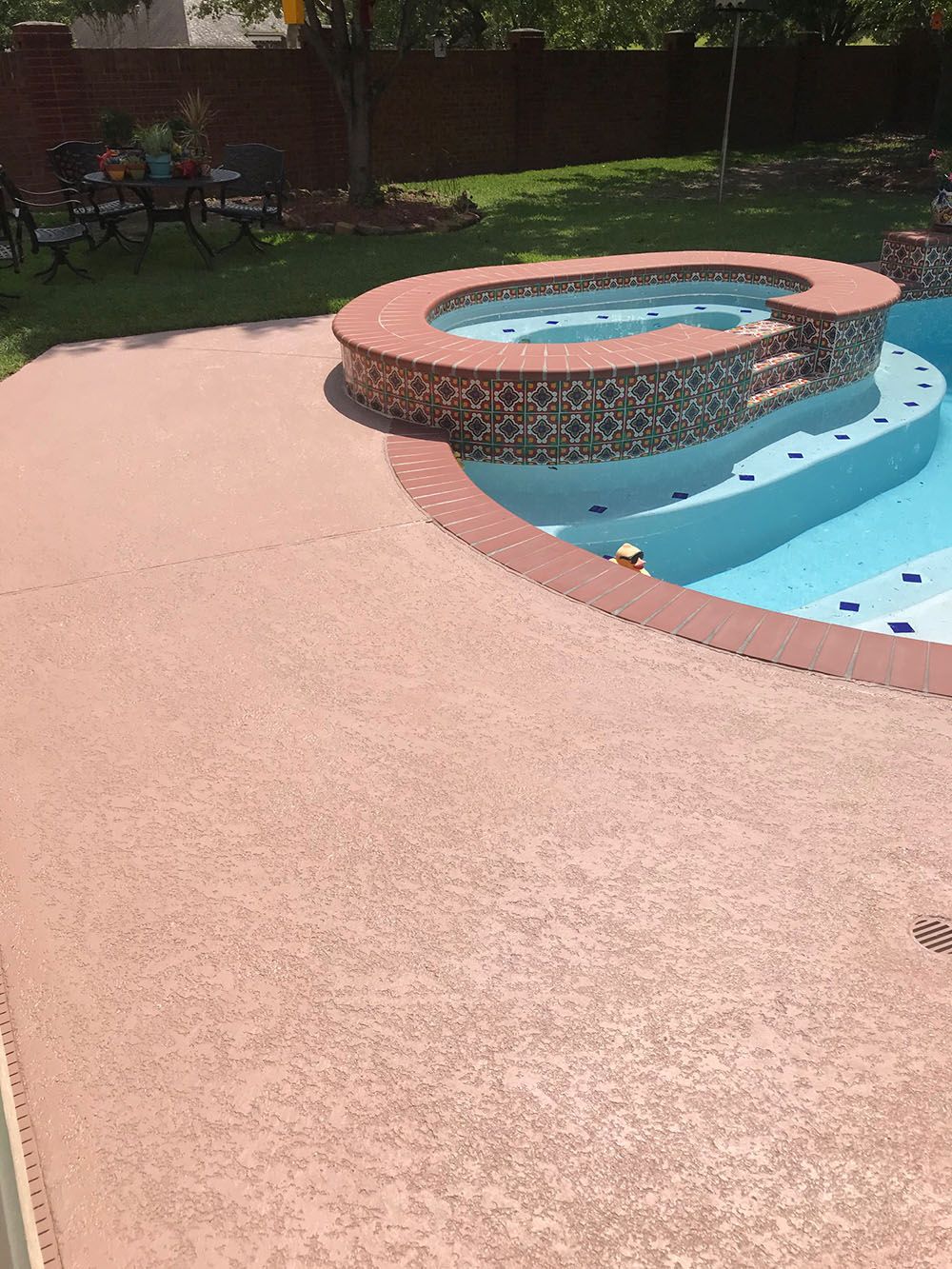 A swimming pool with a hot tub in the middle of it.