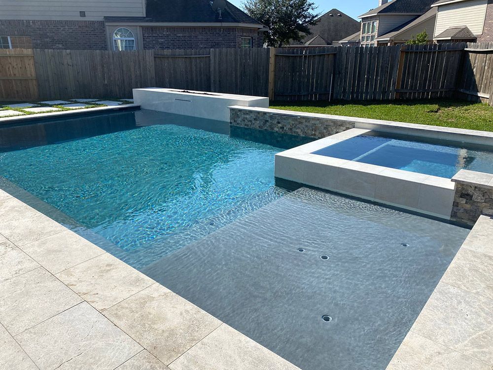 A large swimming pool with a hot tub in the backyard of a house.