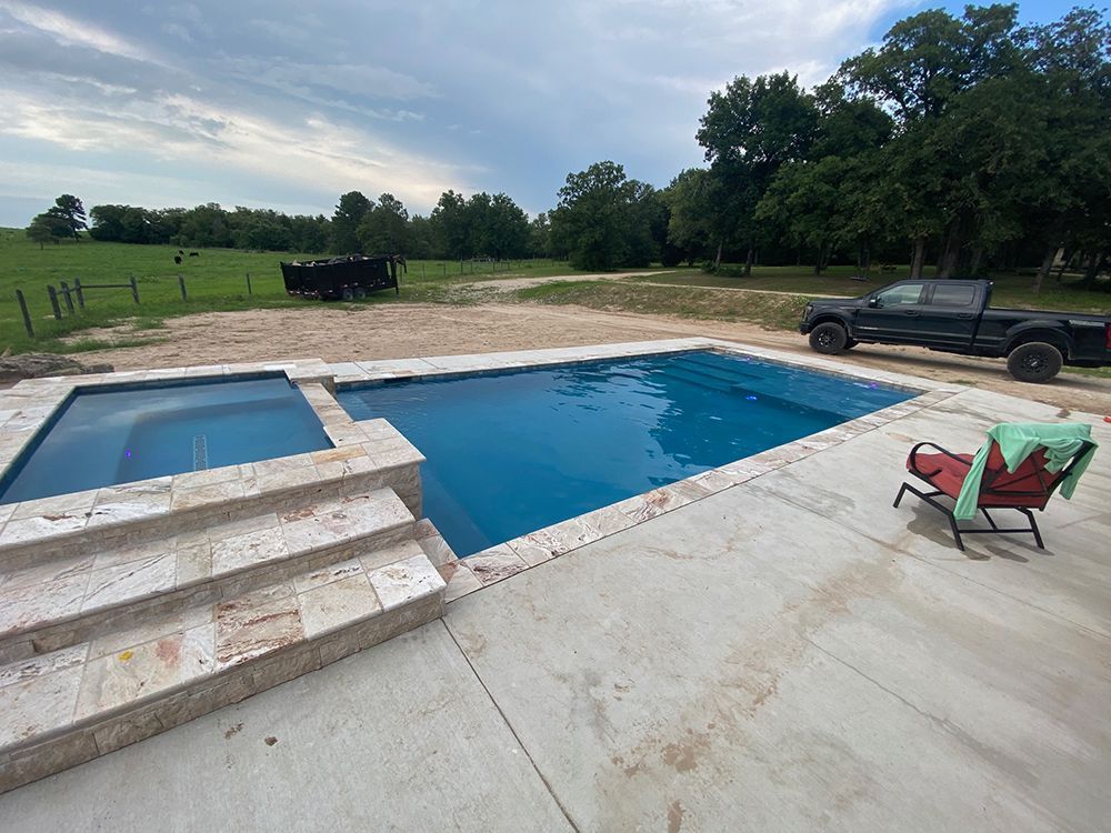 A large swimming pool with a truck parked next to it.