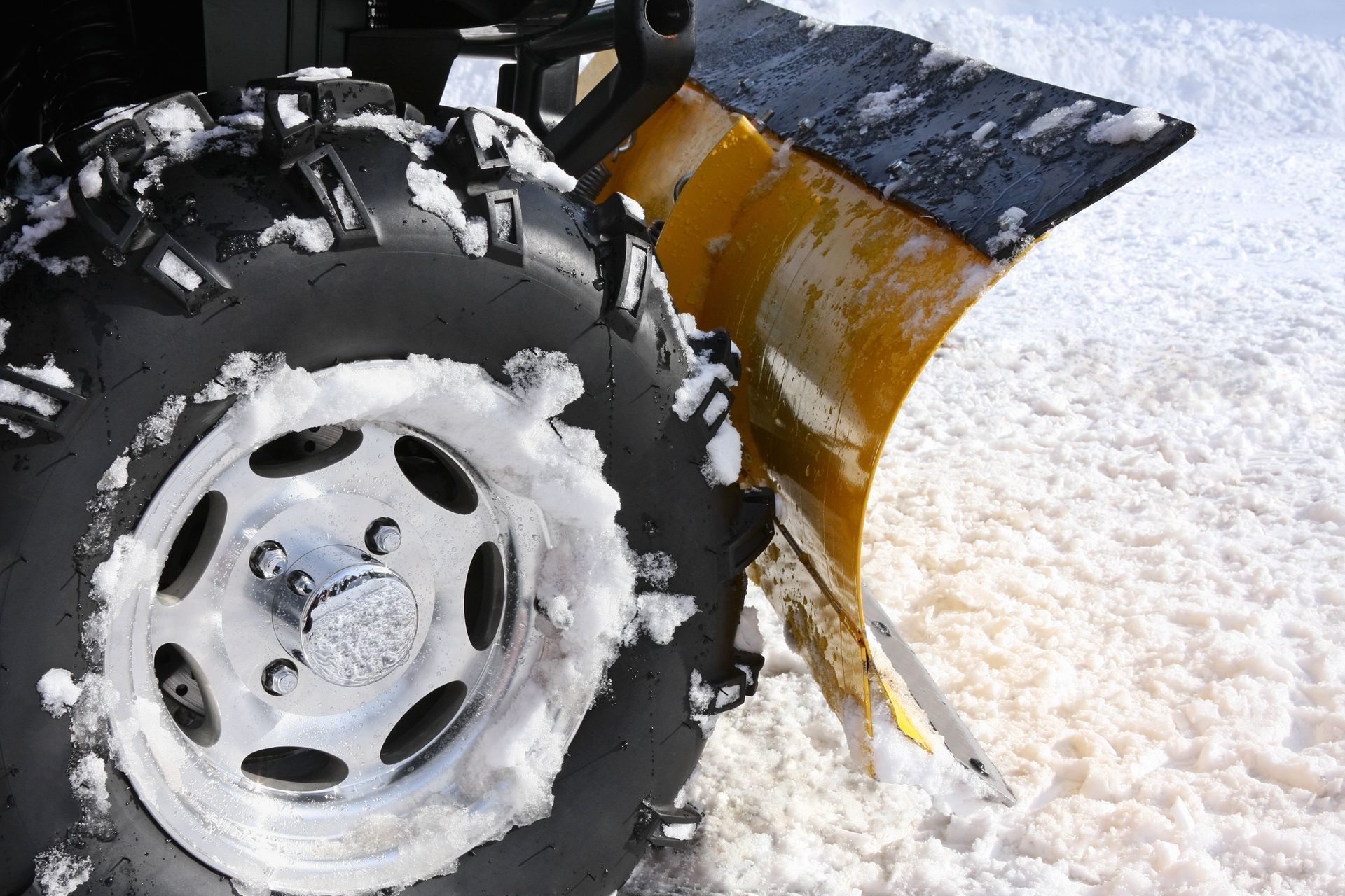 A snow plow is being used to remove snow from a road.
