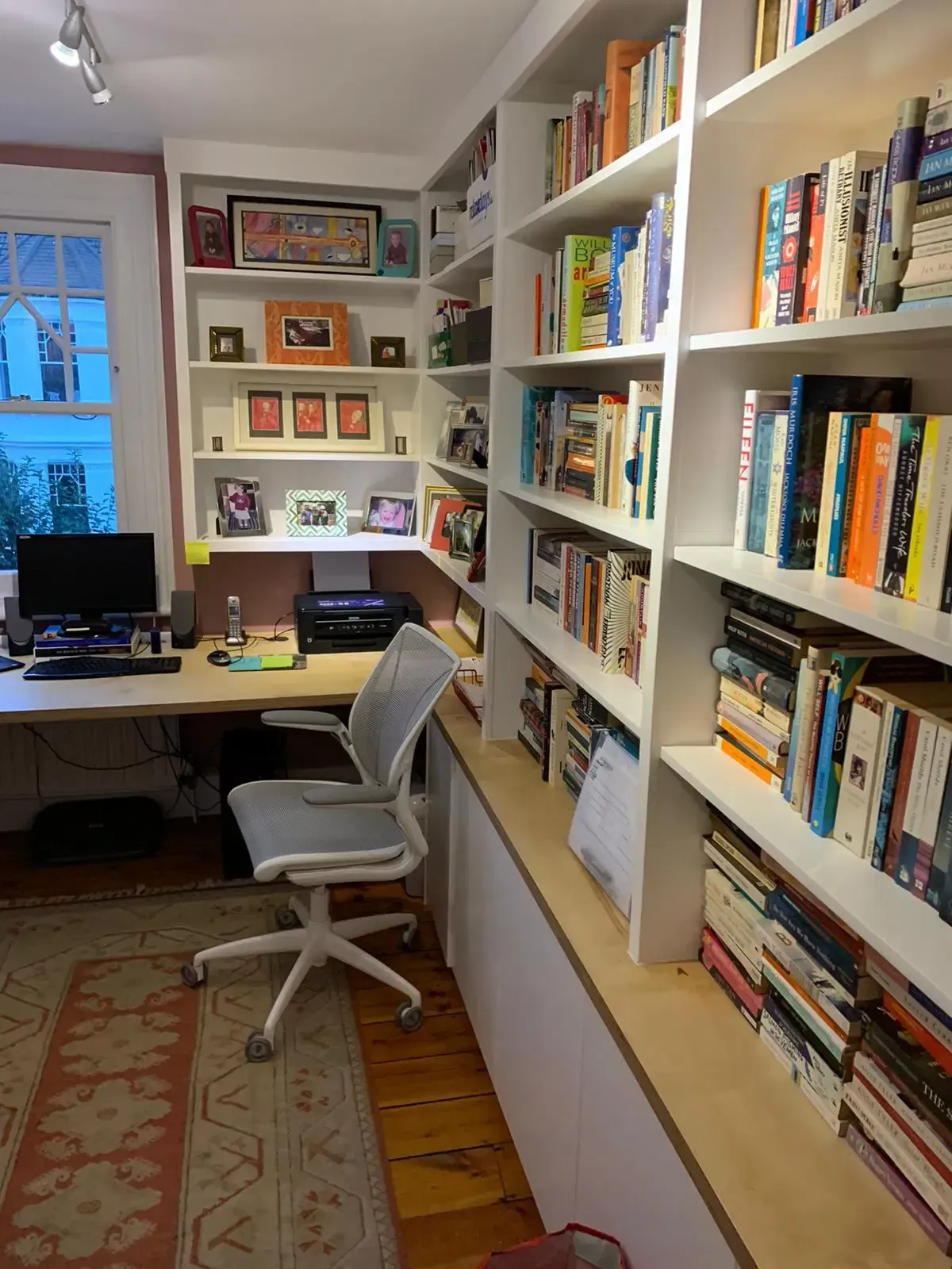 An empty attic with hardwood floors and a skylight.