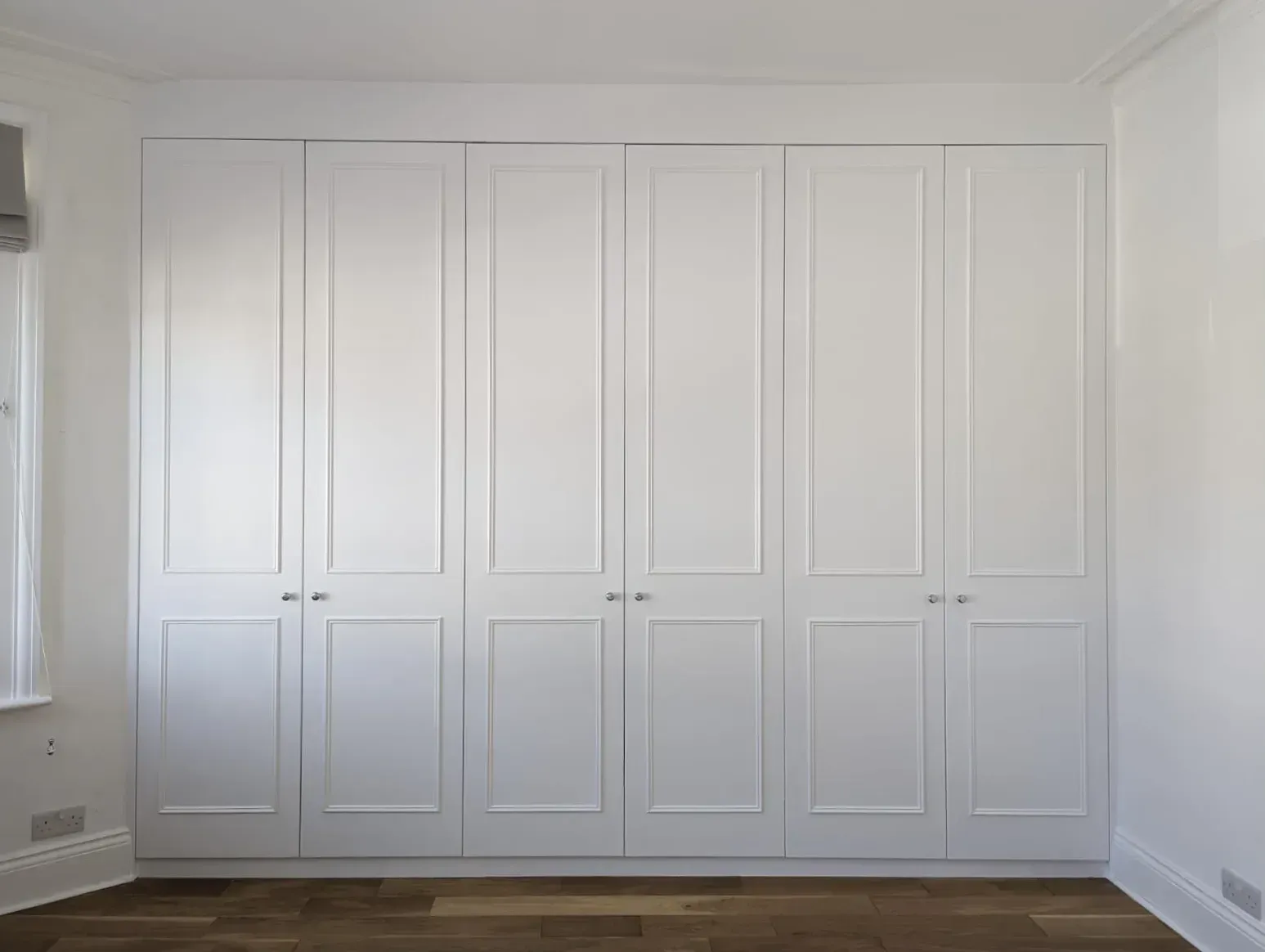 An empty attic with hardwood floors and a skylight.