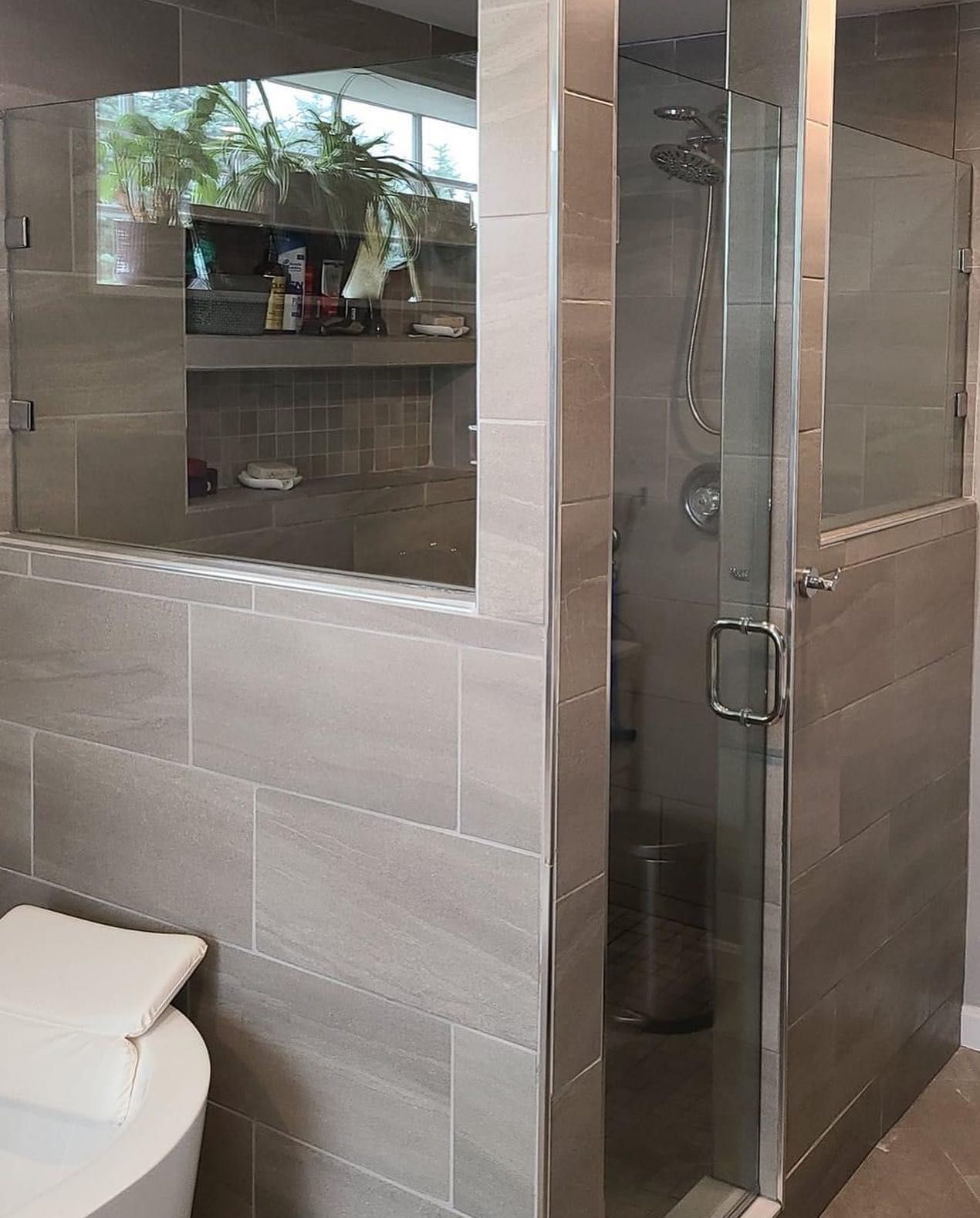 A bathroom with a toilet , shower , and mirror.