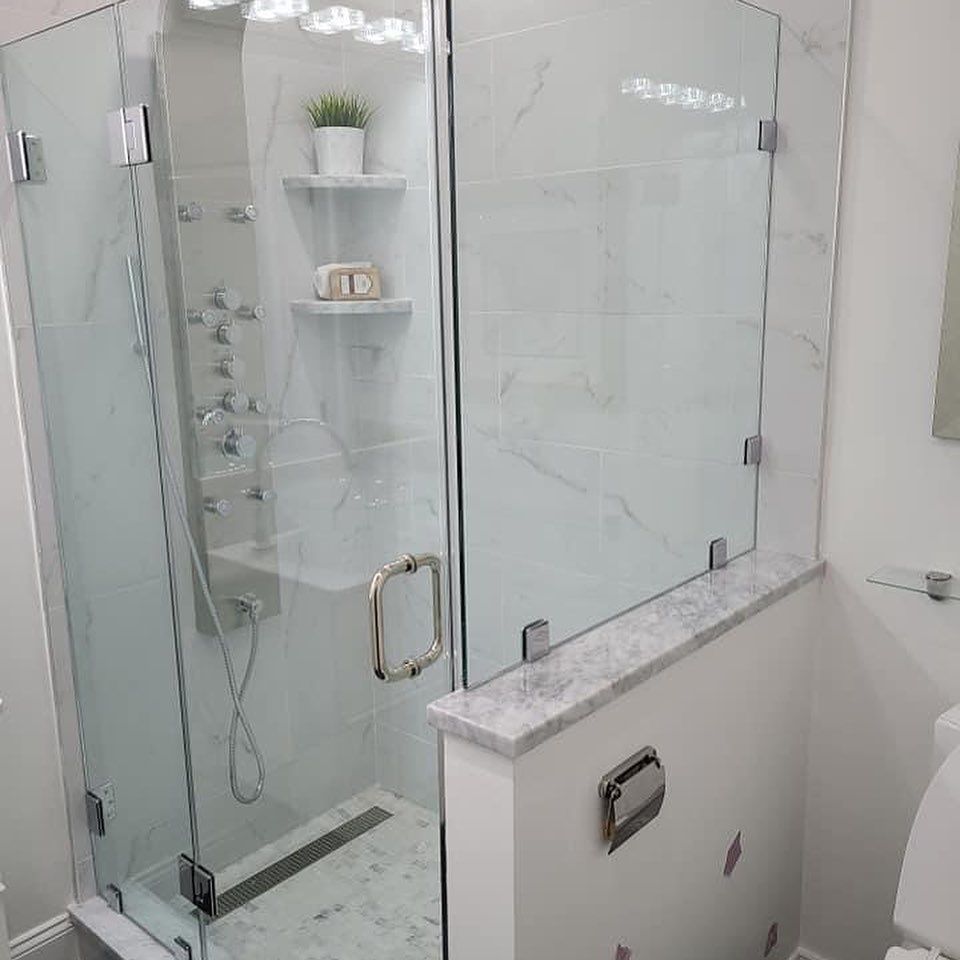 A bathroom with a glass shower door and a toilet.