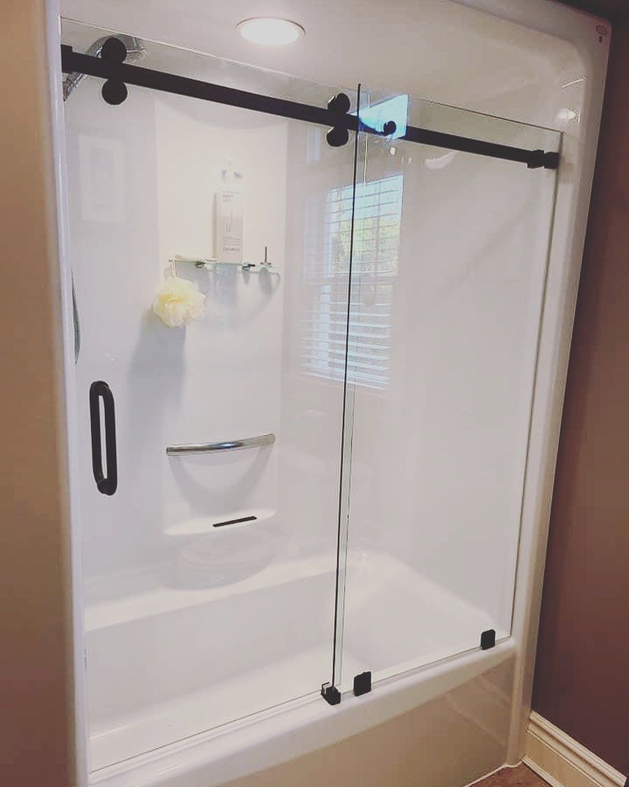 A bathroom with a bathtub and a shower stall with sliding glass doors.