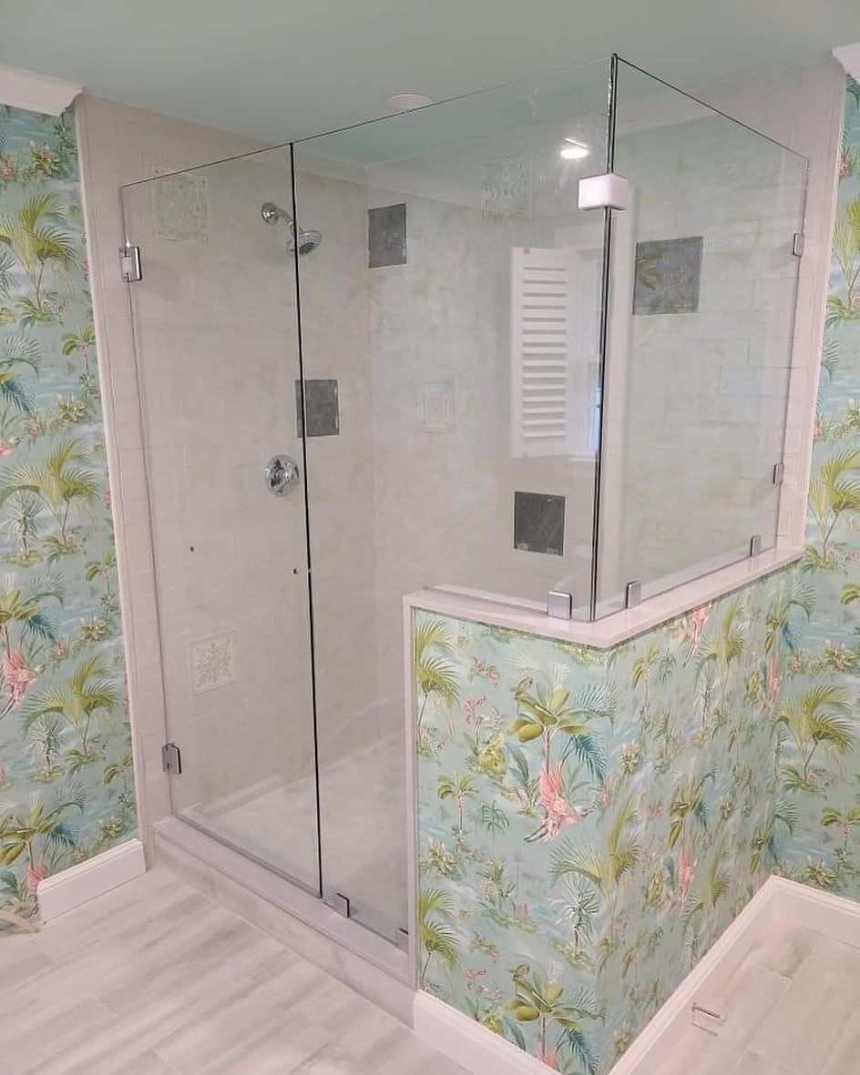 A bathroom with a walk in shower with a glass door.
