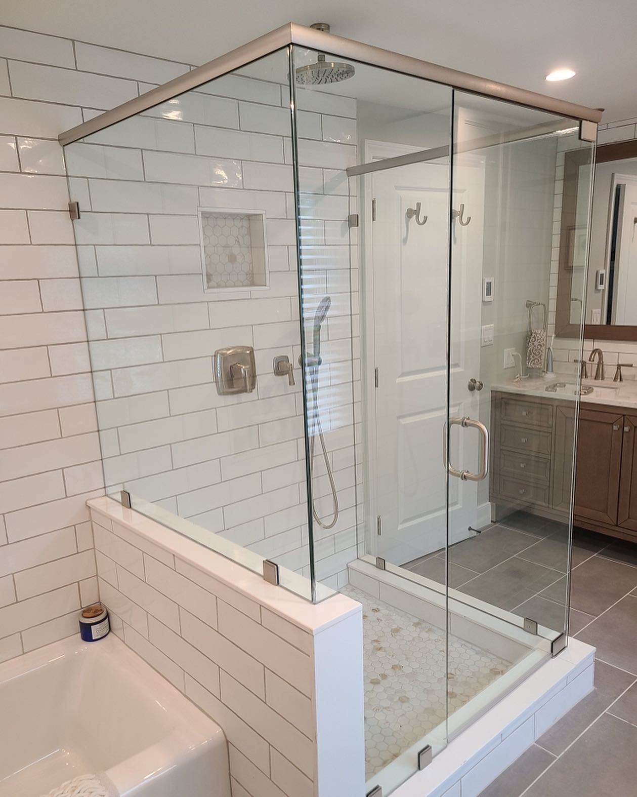 A bathroom with a walk in shower and a bathtub.