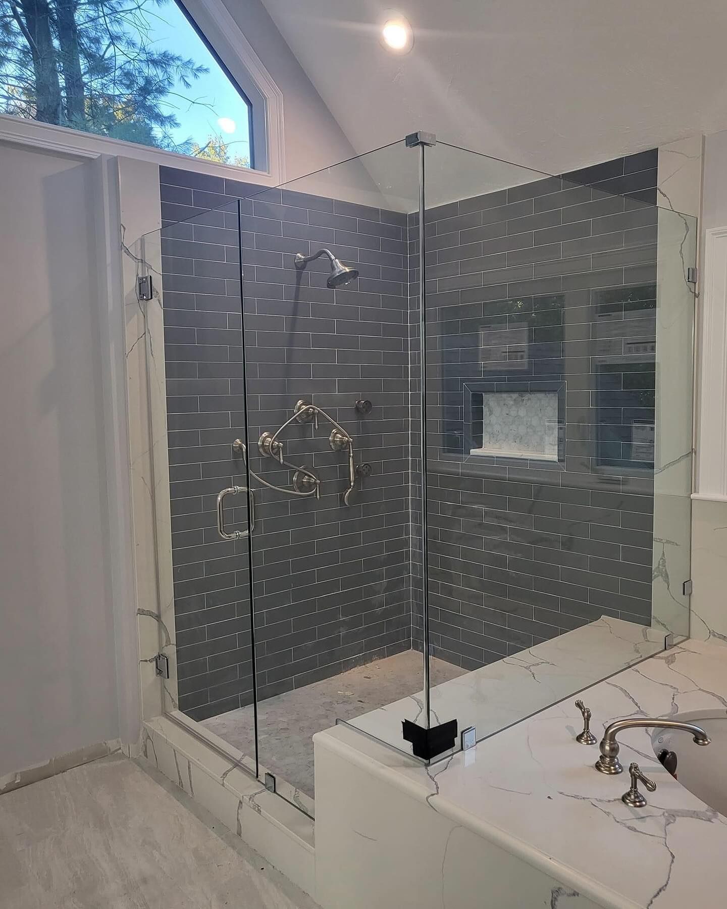 A bathroom with a walk in shower and a sink.