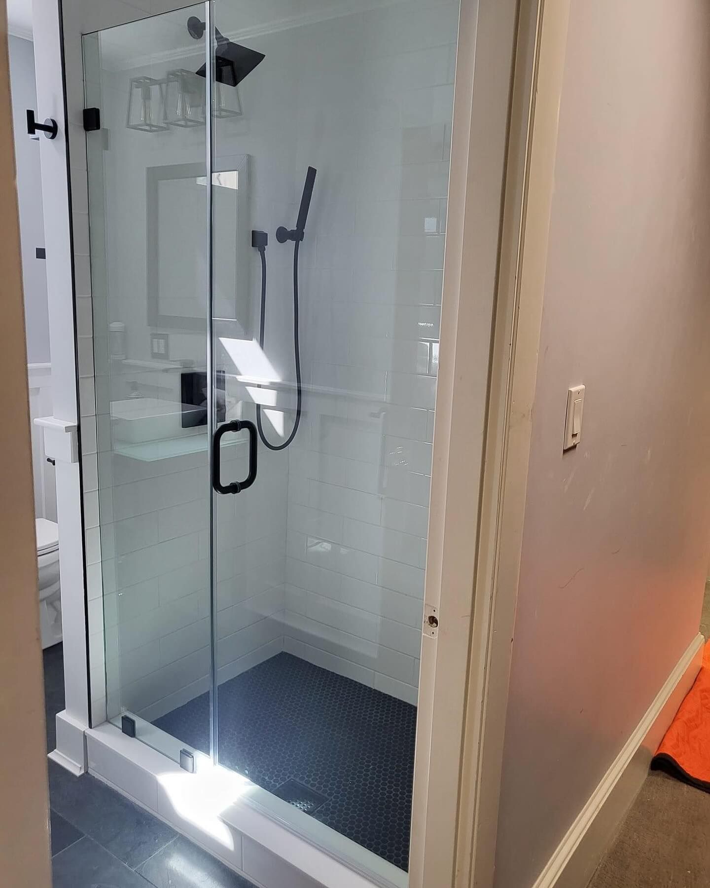A bathroom with a walk in shower and a sink.