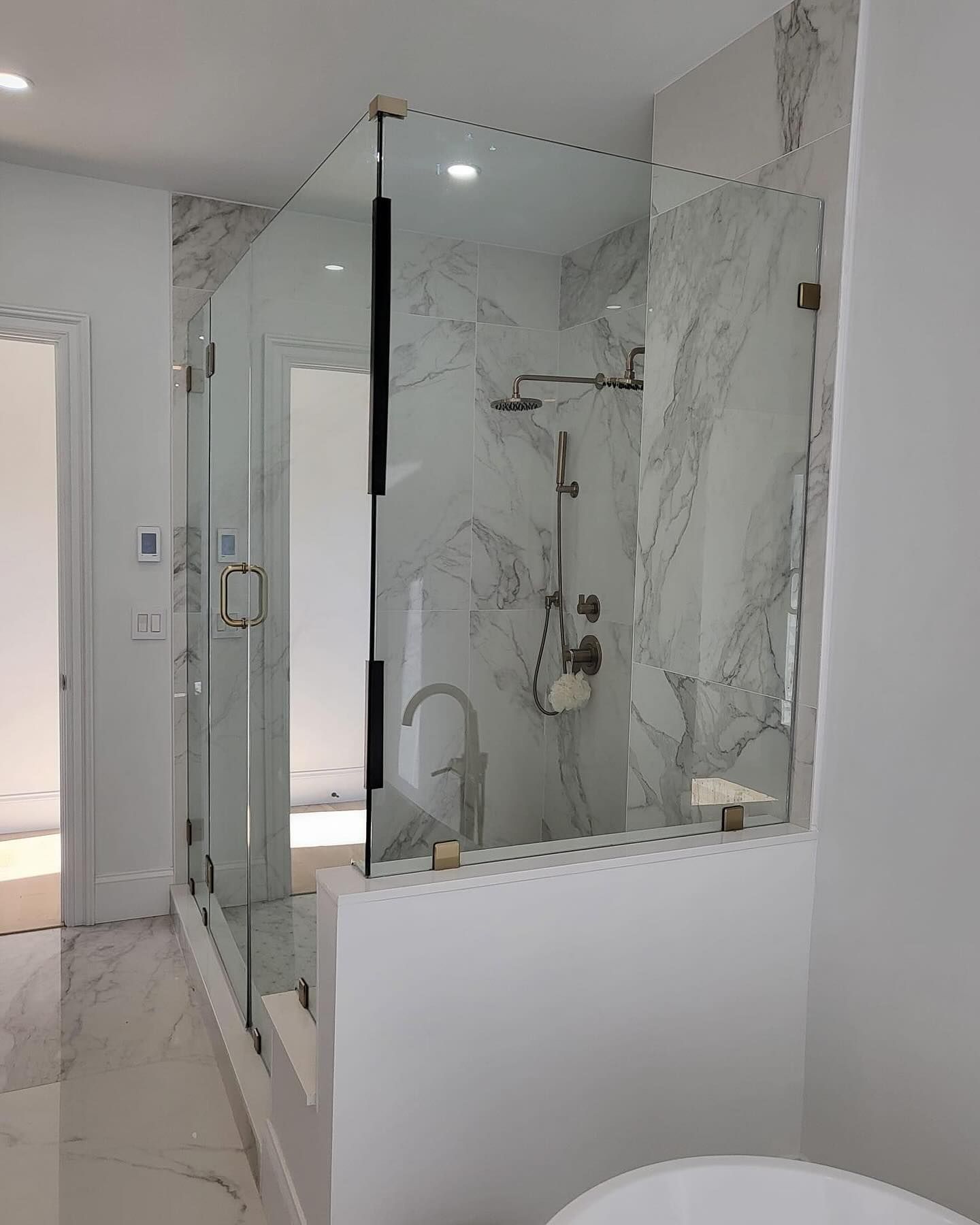 A bathroom with a walk in shower and a bathtub.