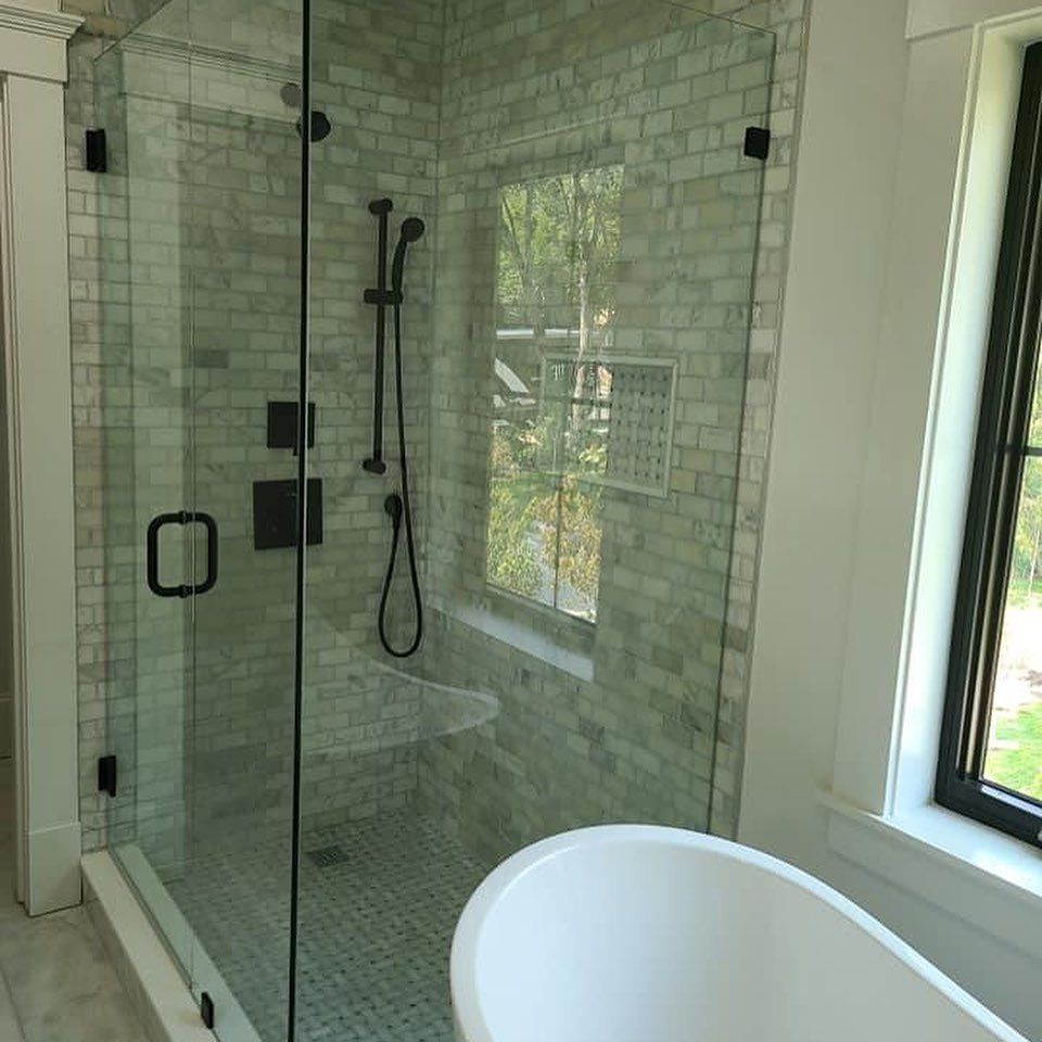 A bathroom with a tub and a shower with a glass door.