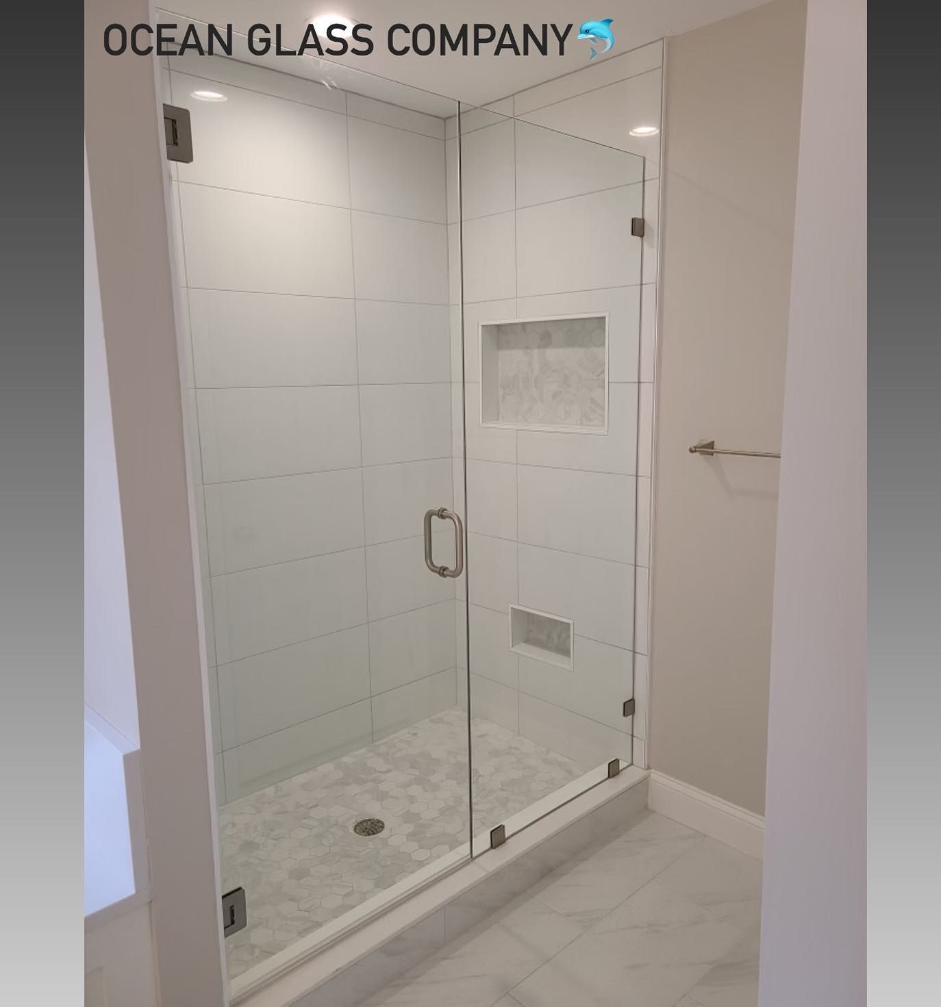 A bathroom with a walk in shower with a glass door.