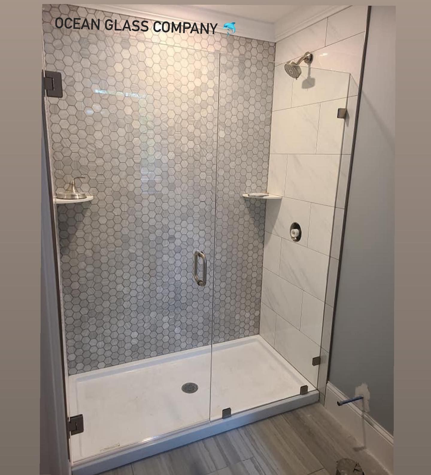 A bathroom with a walk in shower with a glass door.