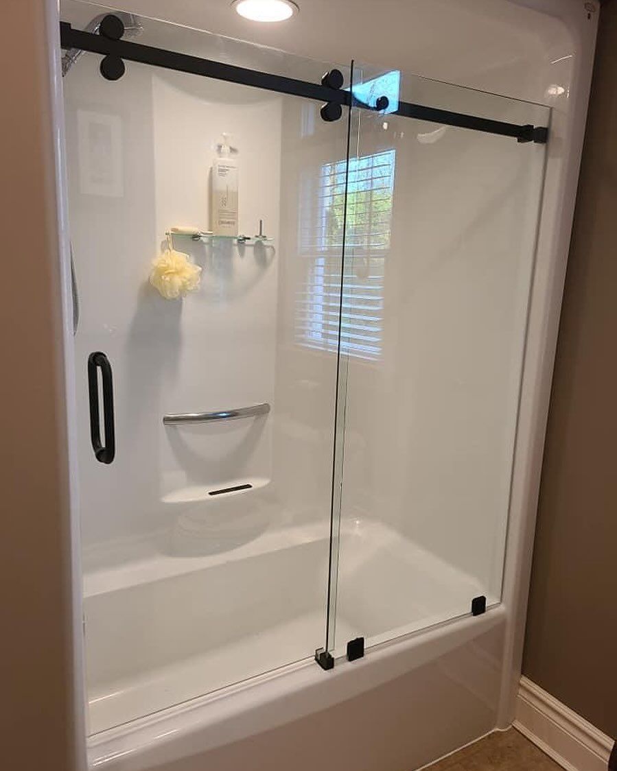 A bathroom with a bathtub and a sliding glass shower door.