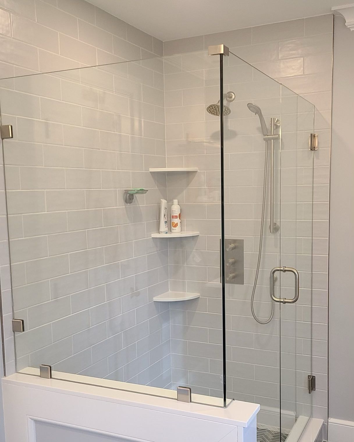 A bathroom with a glass shower door and a shower head.