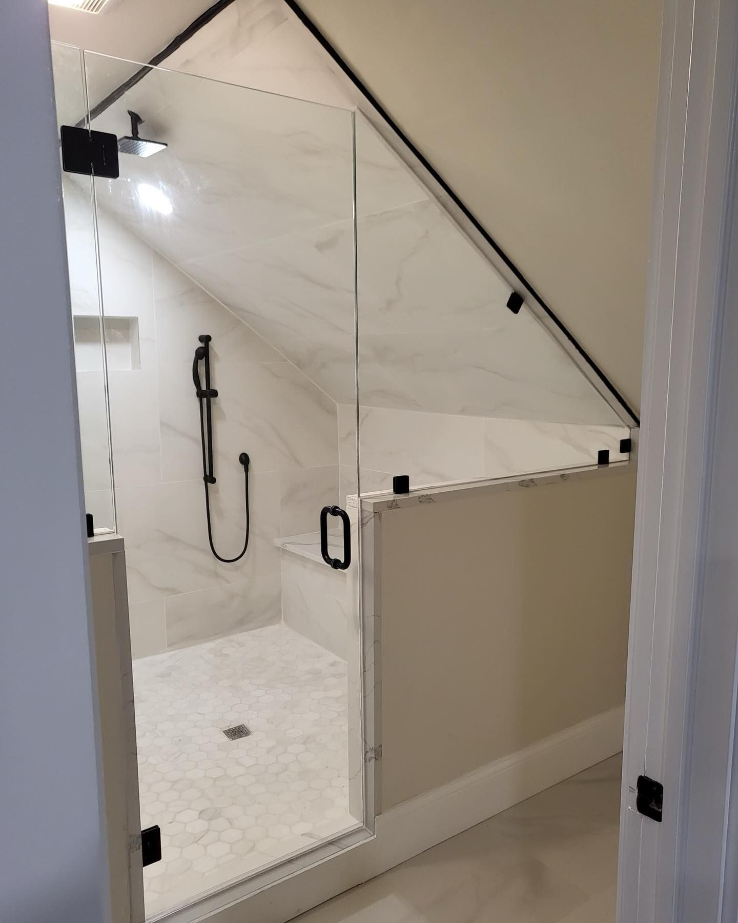 A bathroom with a walk in shower with a glass door.