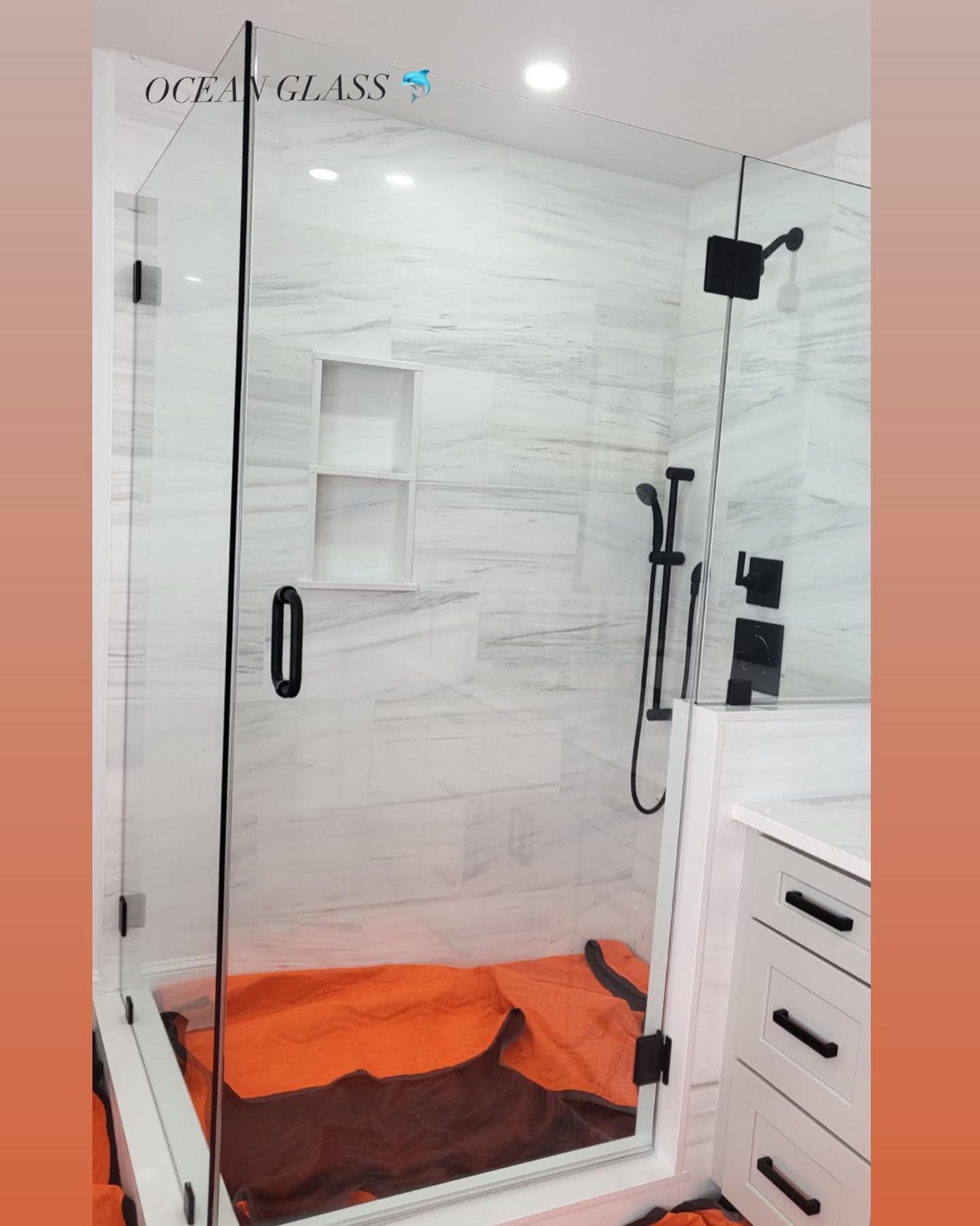 A bathroom with a walk in shower and a sink.