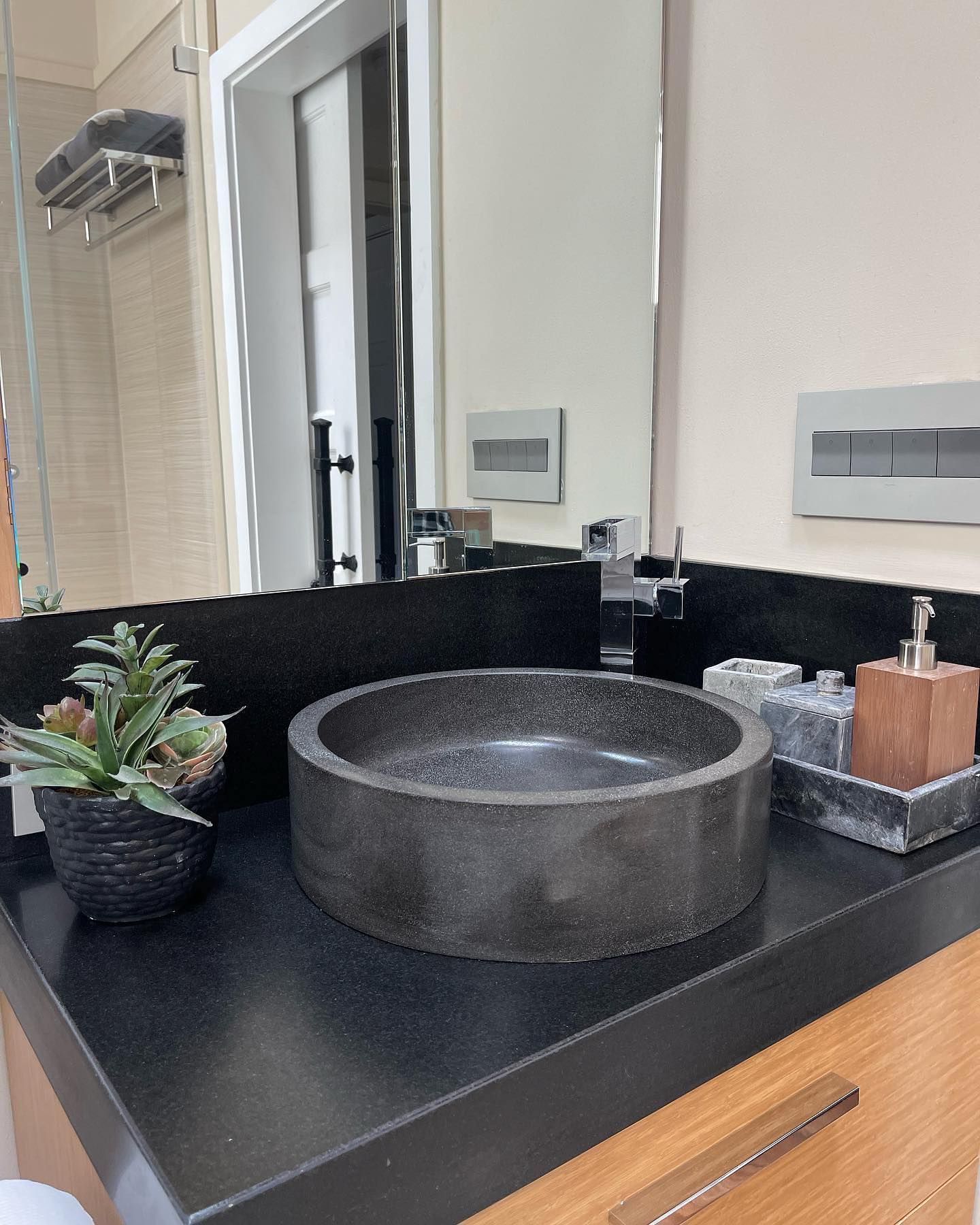 A bathroom with a round sink and a mirror