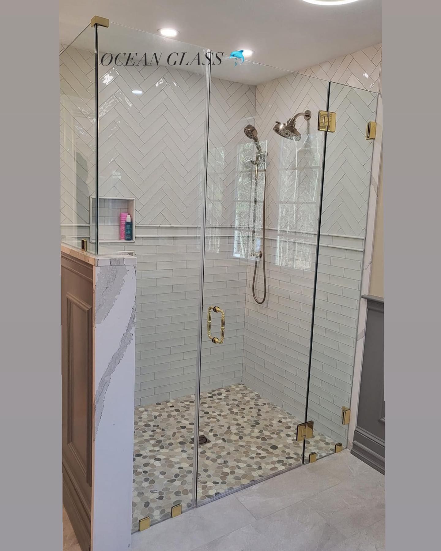 A bathroom with a walk in shower with a glass door.