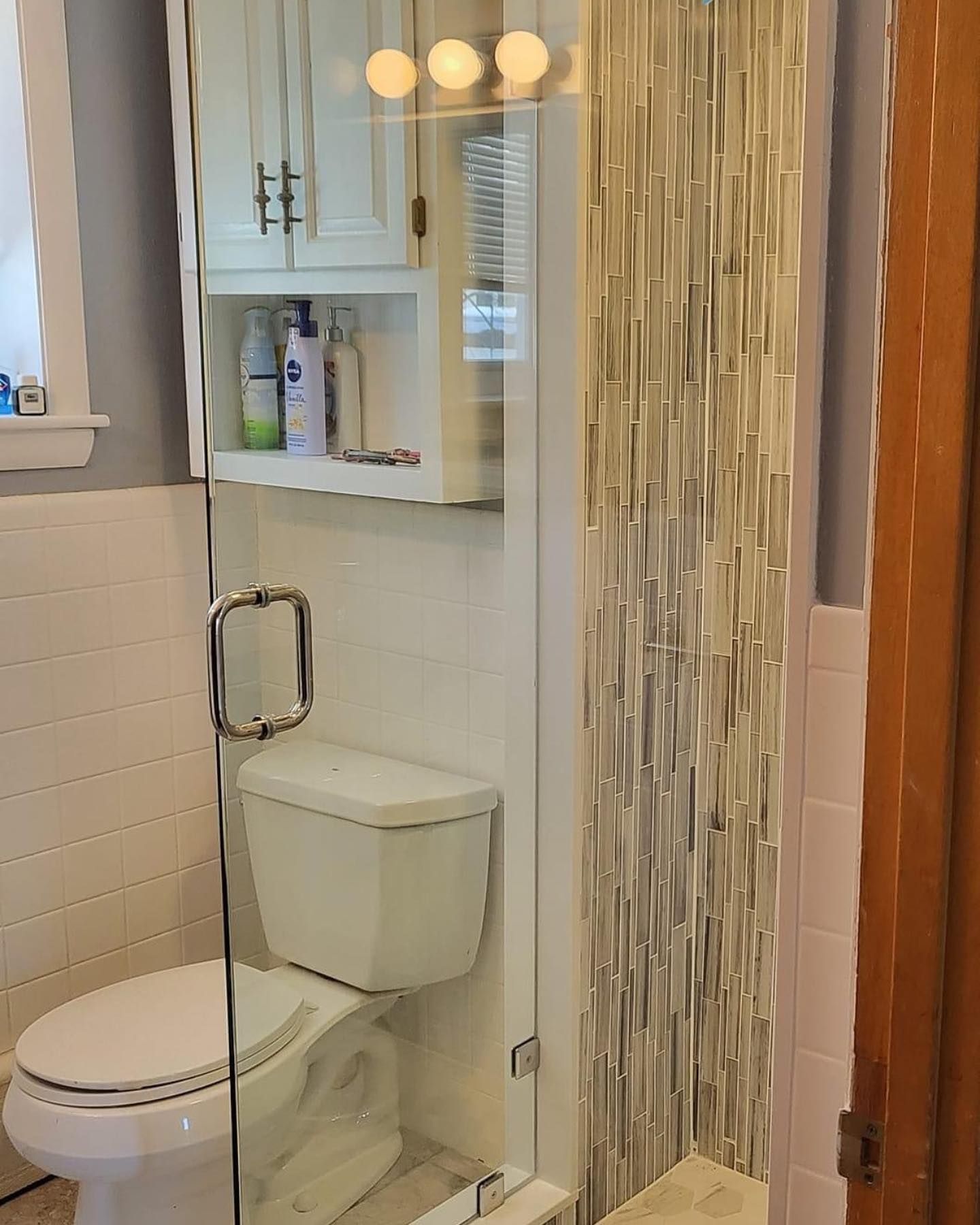 A bathroom with a toilet and a glass shower door.