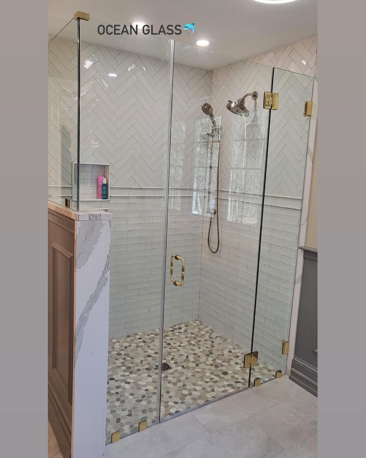 A bathroom with a walk in shower with a glass door.