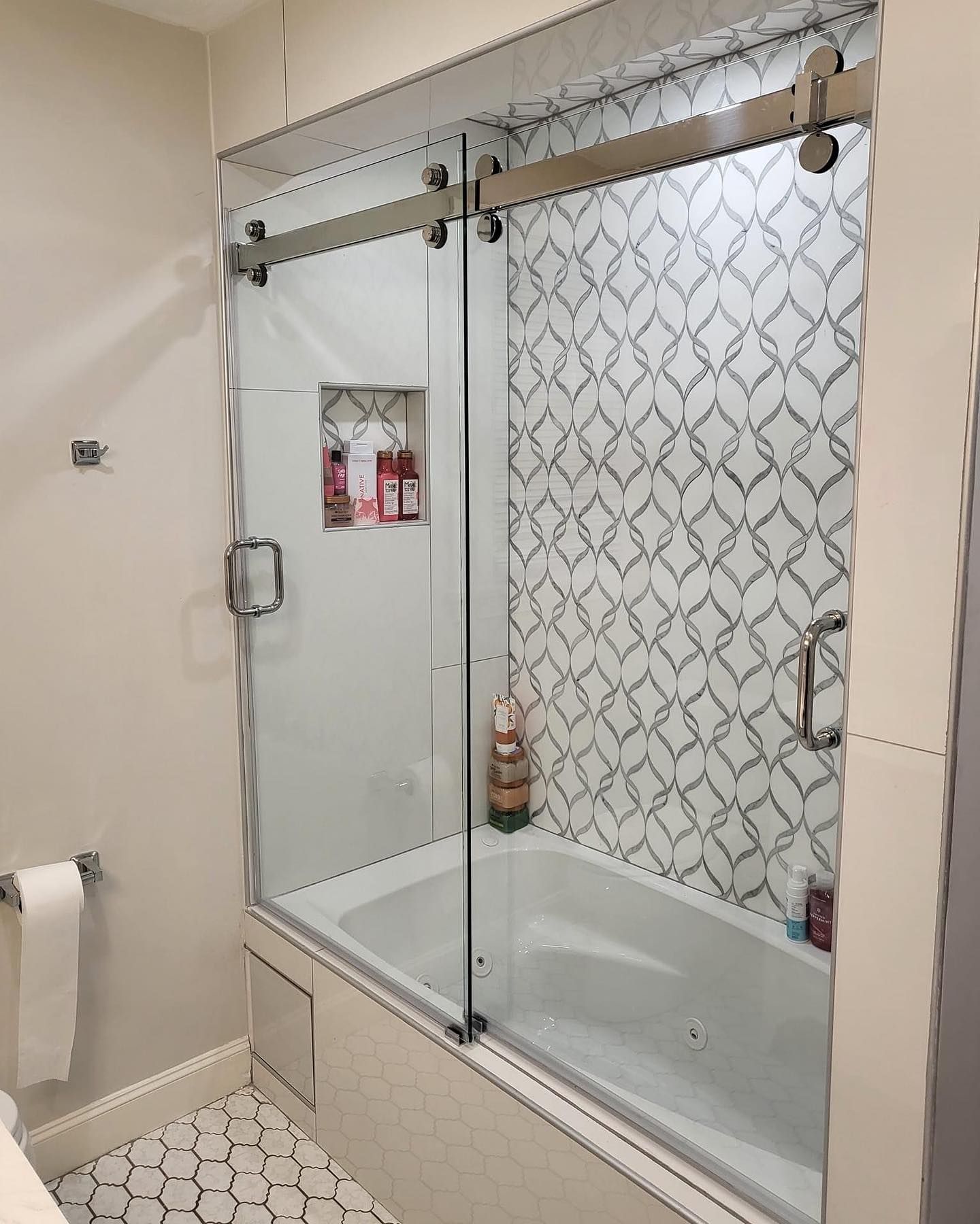 A bathroom with a bathtub and a sliding glass shower door.