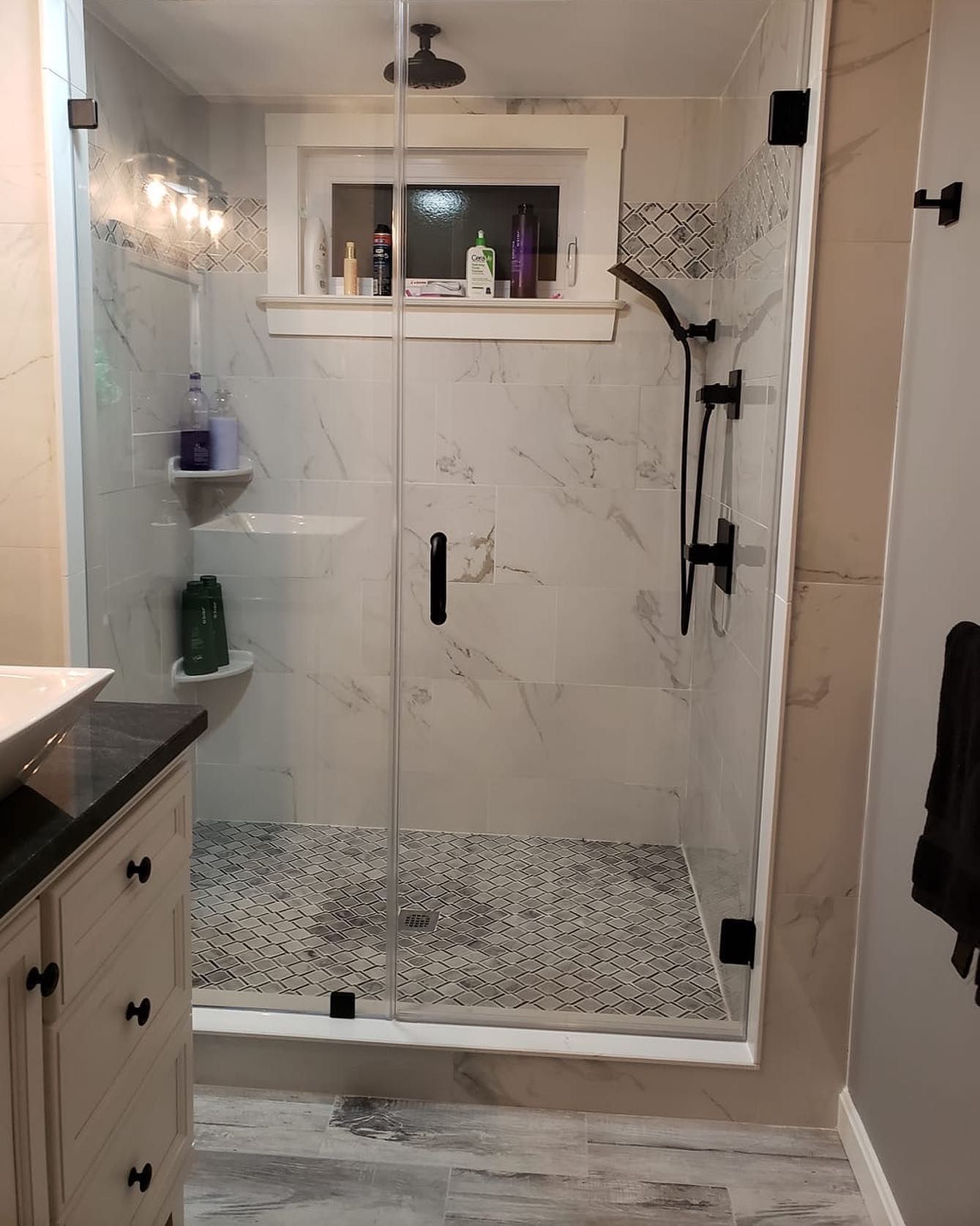 A bathroom with a walk in shower and a sink.