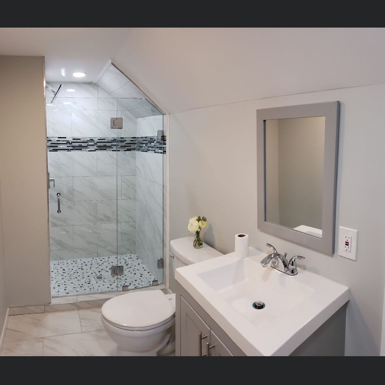 A bathroom with a toilet a sink and a mirror