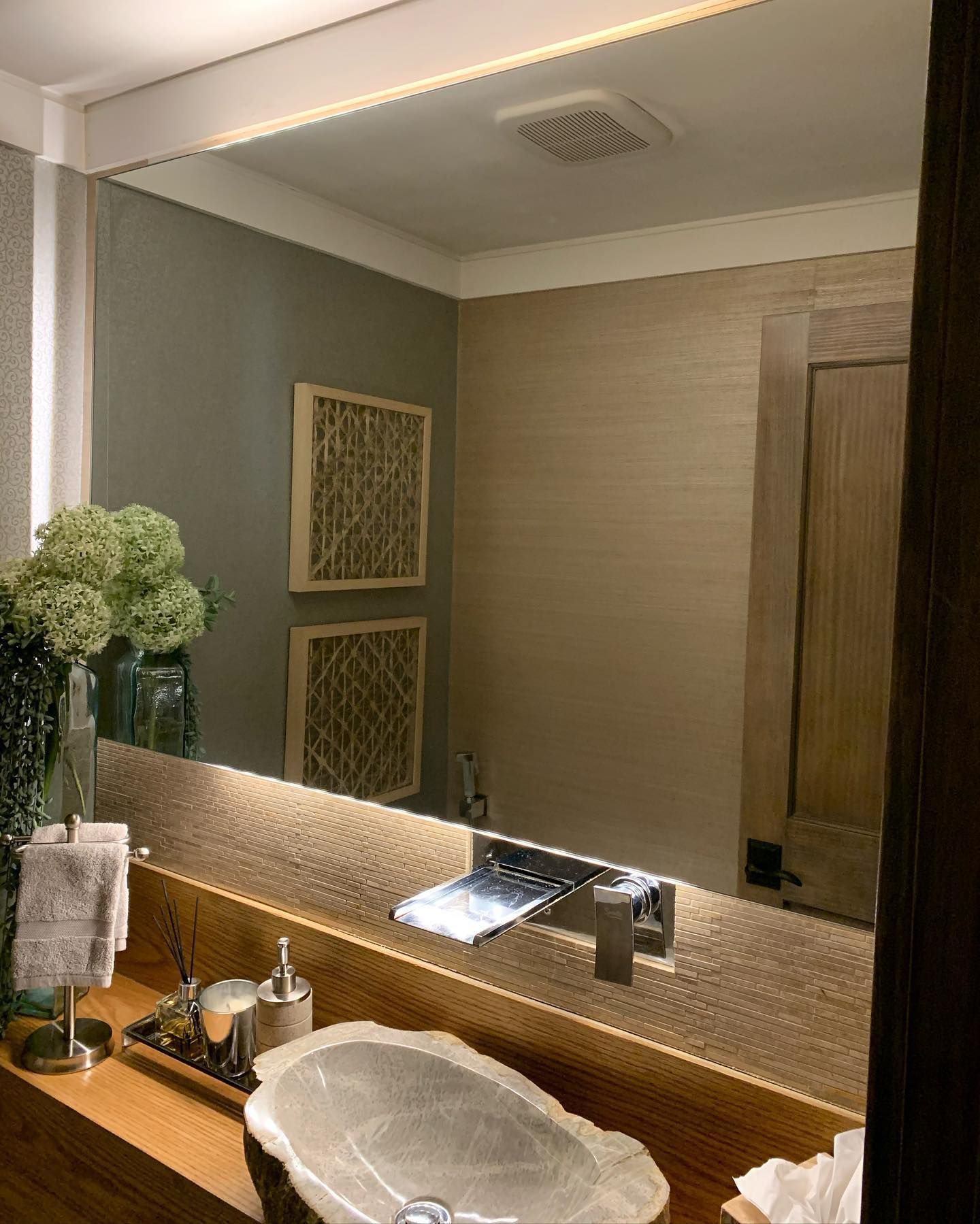 A bathroom with a sink and a large mirror