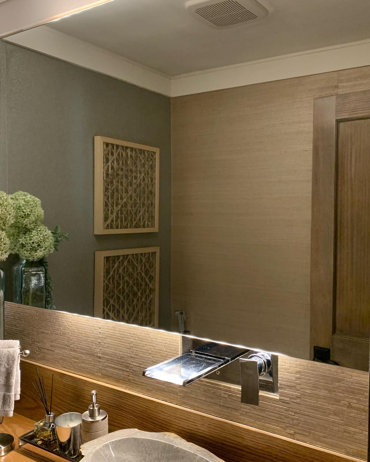 A bathroom with a sink and a large mirror