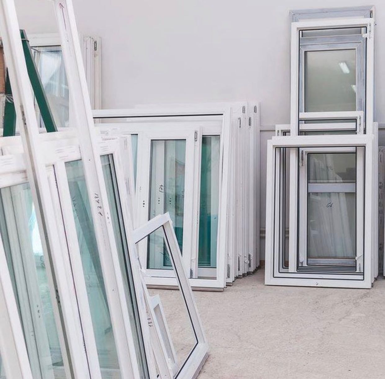 A bunch of windows are stacked on top of each other in a room.