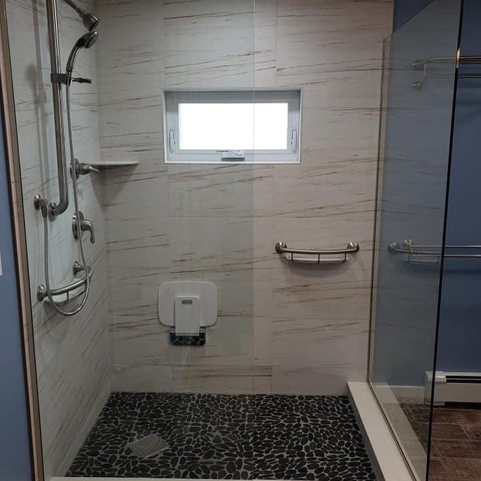 A bathroom with a walk in shower and a window.