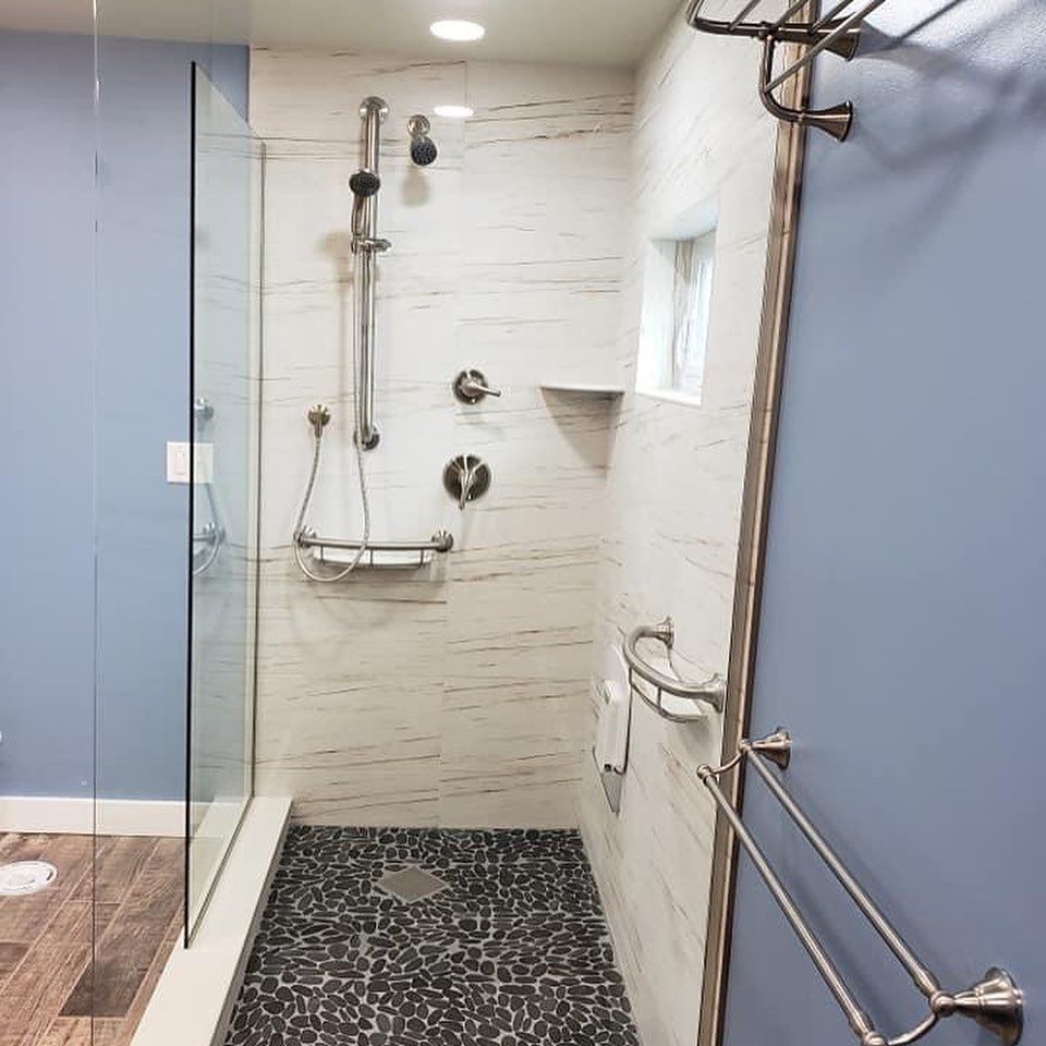 A bathroom with a walk in shower with a glass door