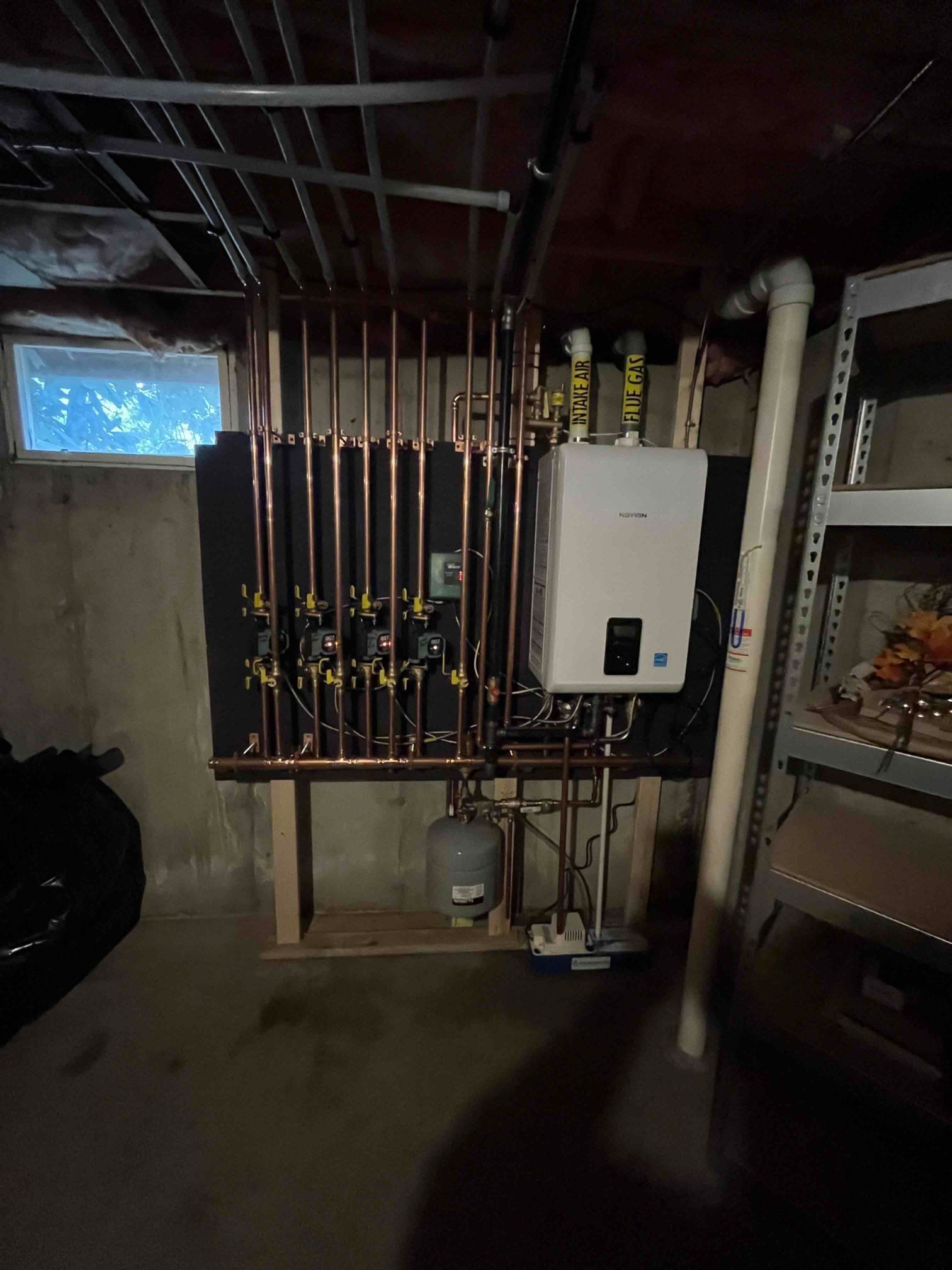 Copper pipes and plumbing, wall-mounted boiler, basement setting.