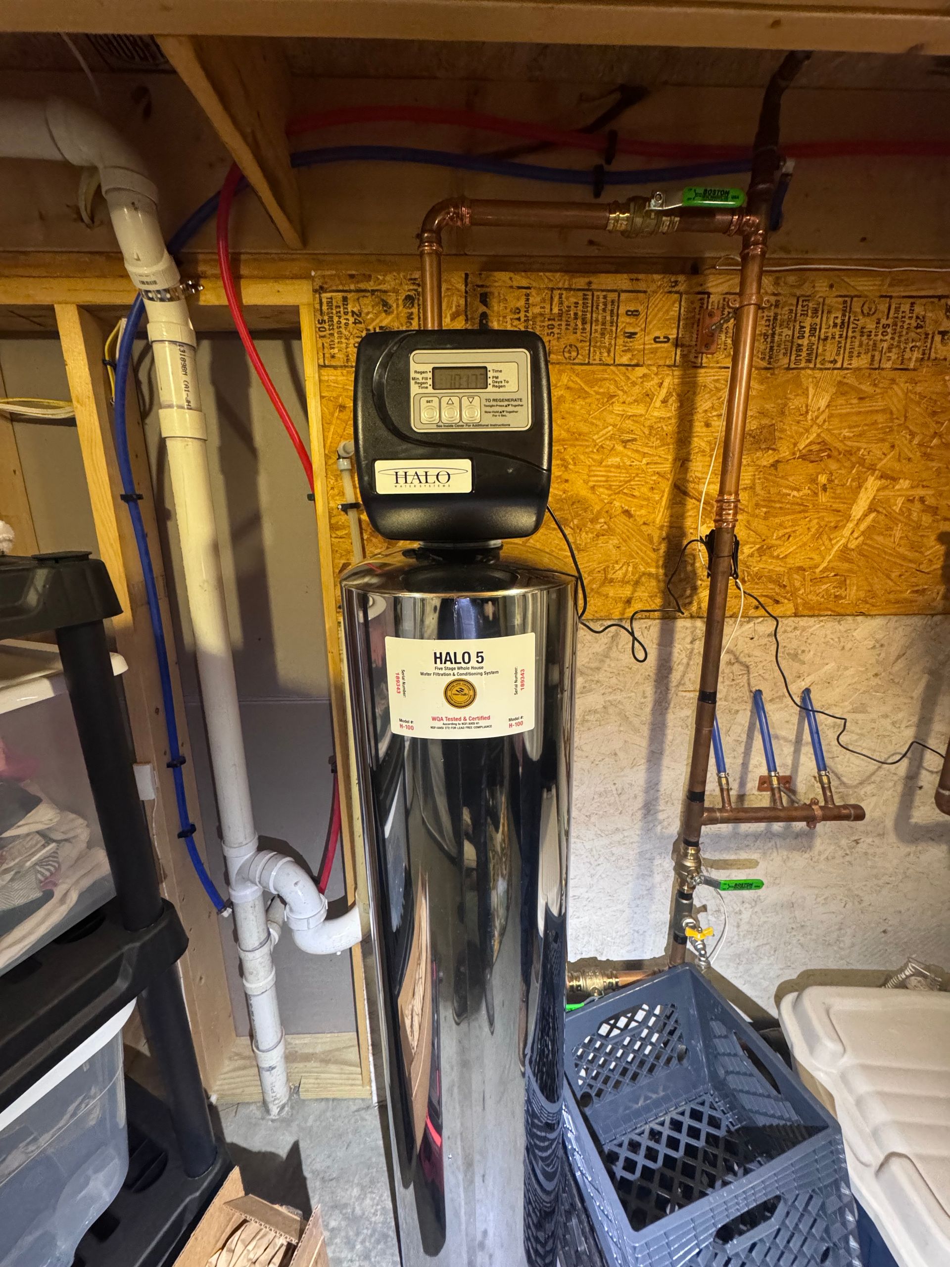 Water softener system in a basement setting with plumbing and digital controls.