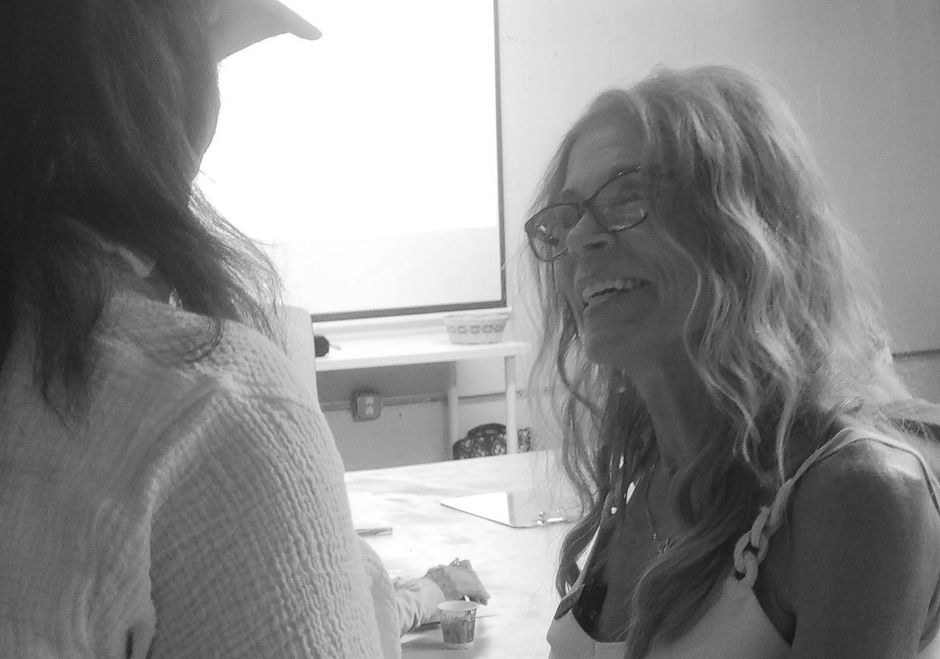 Two women are talking to each other in a black and white photo.